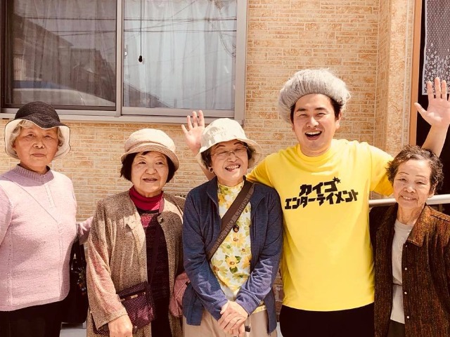 施設に通所する利用者の人たちと一緒に笑う石田竜生さん（右から2人目）